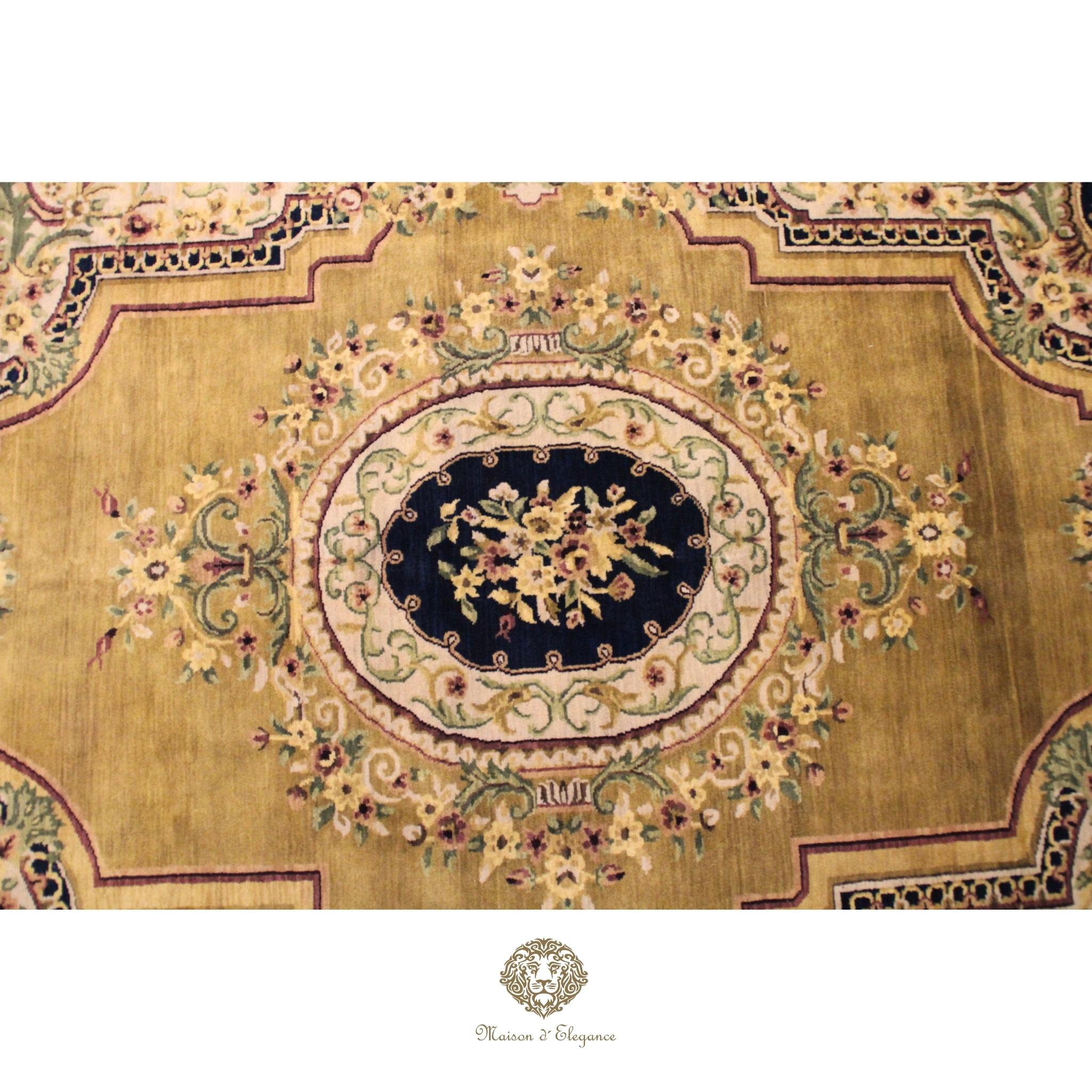 Close-up of an ornate rug with intricate patterns and a brand logo at the bottom.