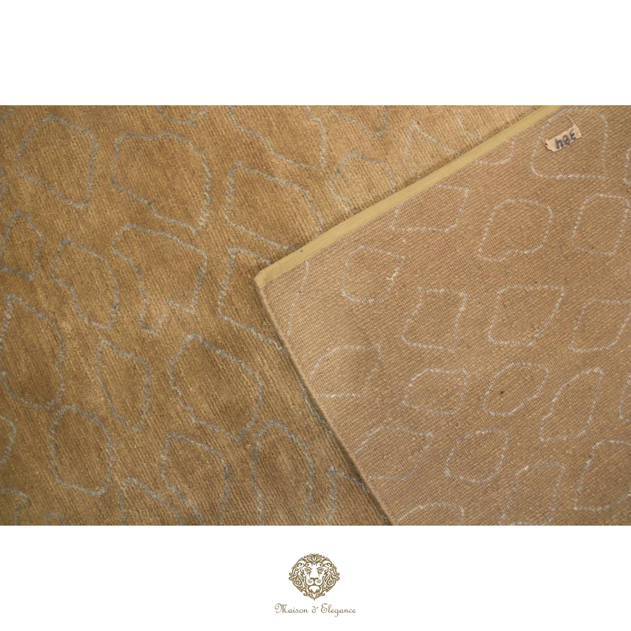Close-up of a textured brown fabric with geometric pattern, featuring a brand logo at the bottom.