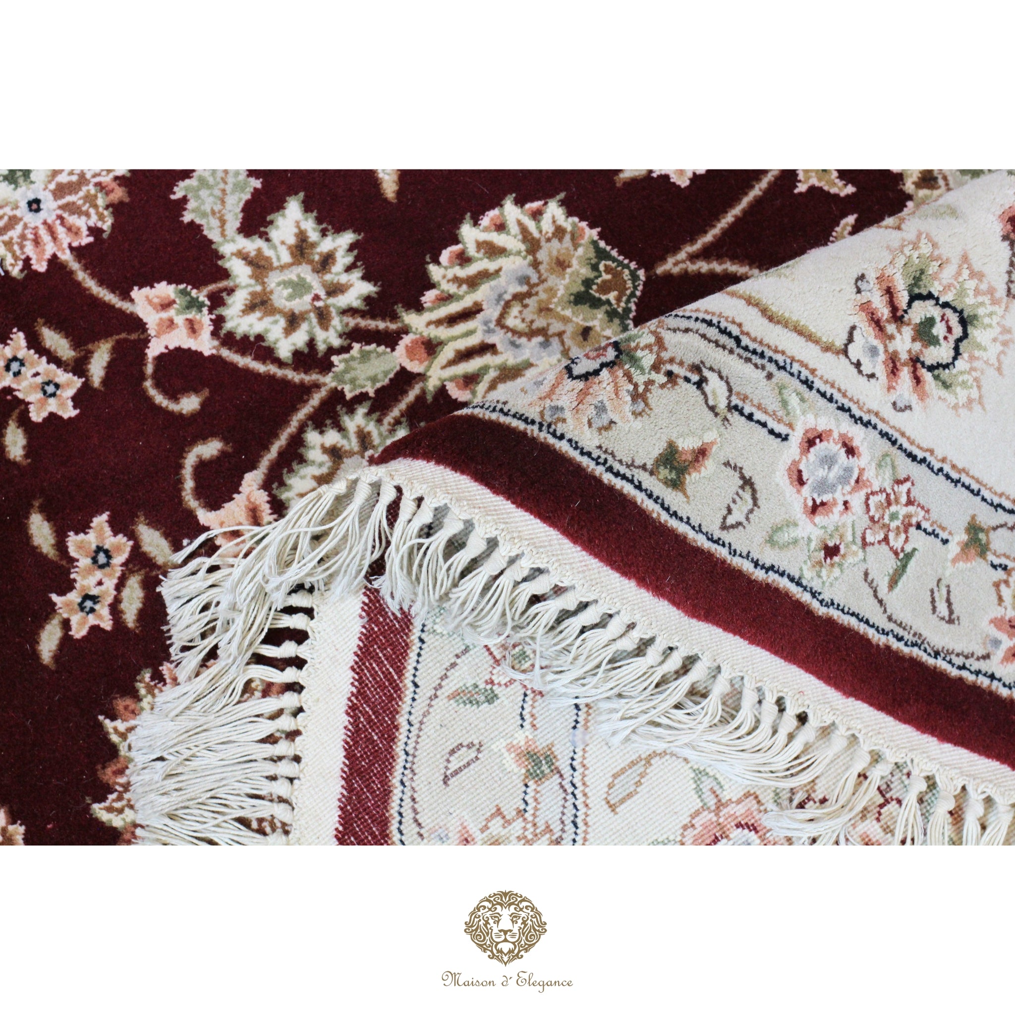 Close-up of a patterned rug with floral designs and fringes on a red background.