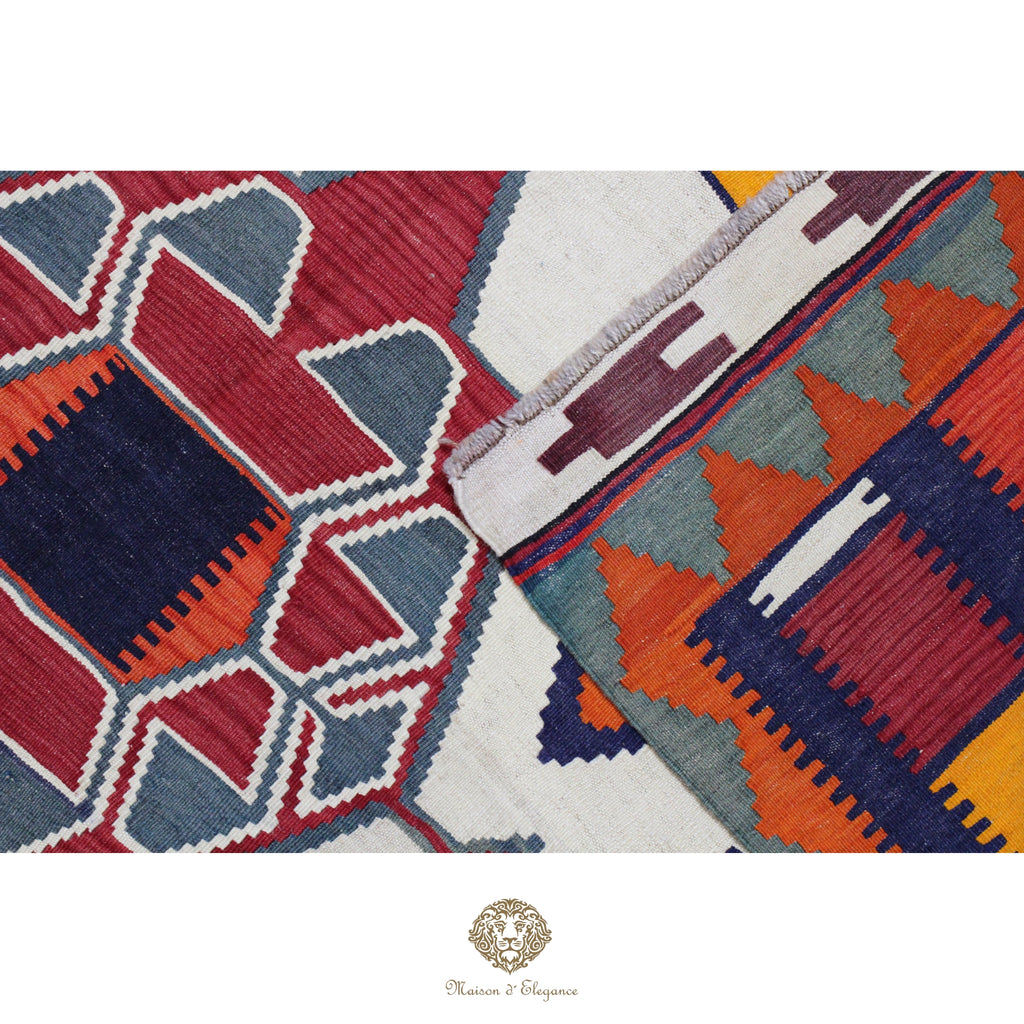 Close-up of a geometric patterned rug with vibrant colors on a white background.