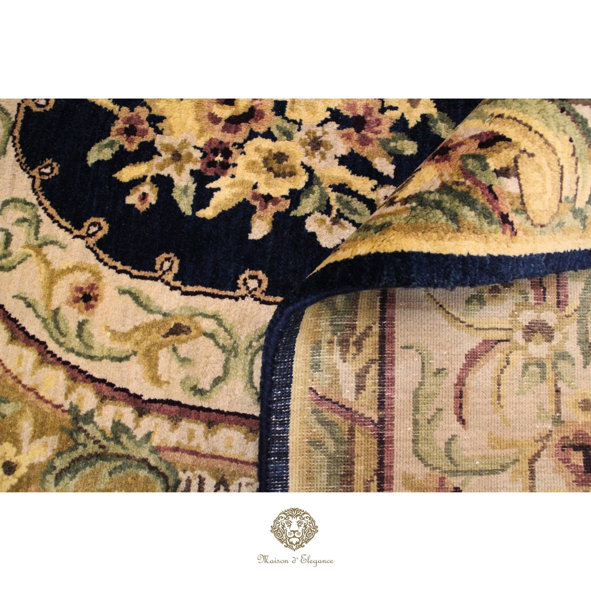 Close-up of a floral patterned rug with a brand logo at the bottom.