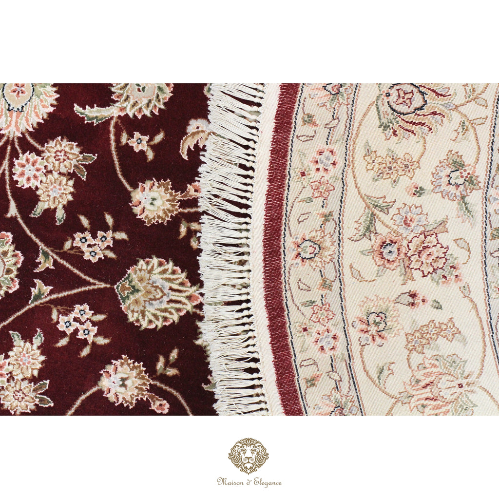 Close-up of a floral-patterned rug with a visible brand logo.