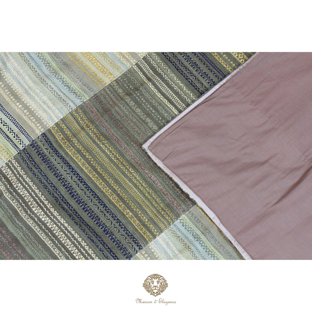 Patchwork fabric with striped patterns in green, blue, and brown on a white background.
