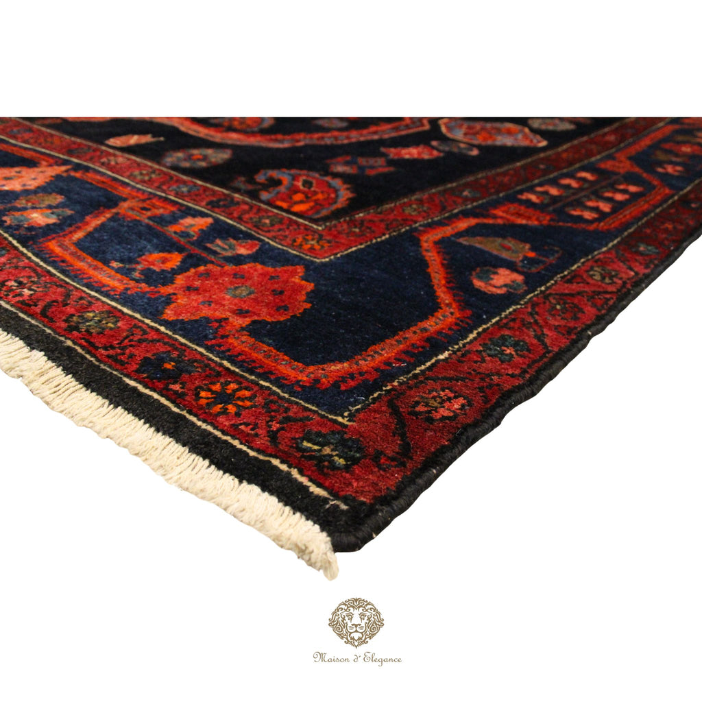 Close-up of a red and black patterned rug with visible brand logo.