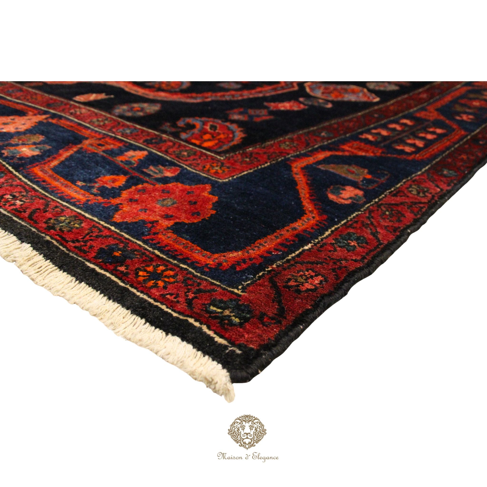 Close-up of a red and black patterned rug with visible brand logo.