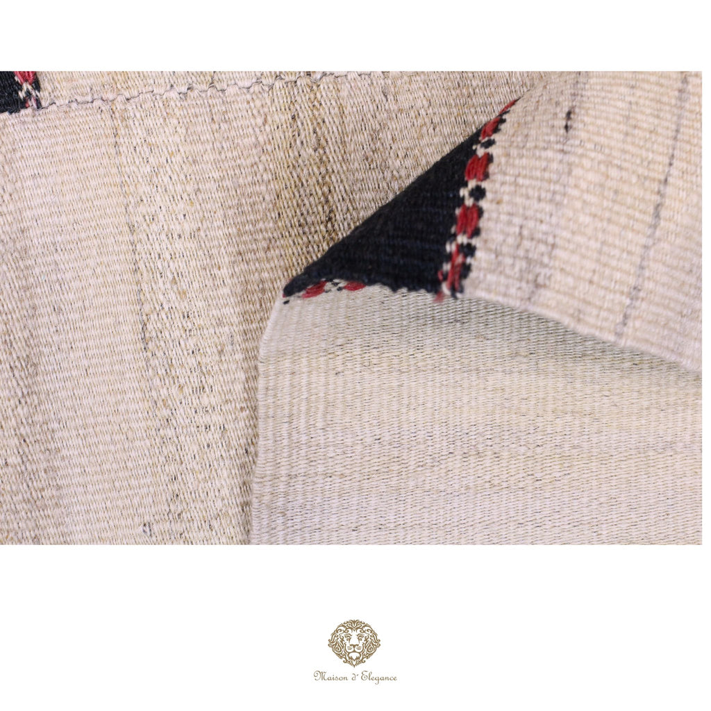 Close-up of woven fabric with black and red pattern, brand logo visible