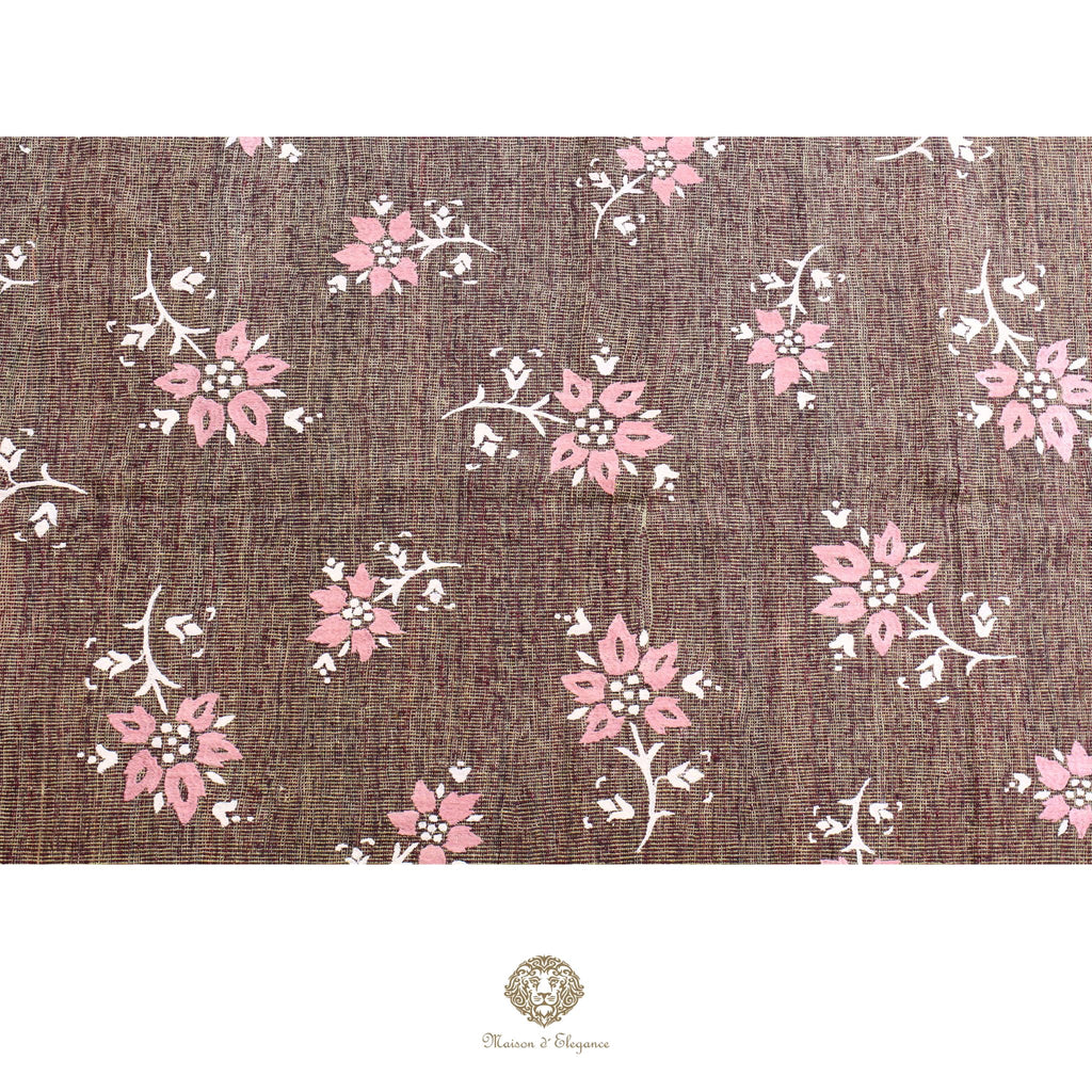 Floral pattern on a textured brown background with a brand logo at the bottom.
