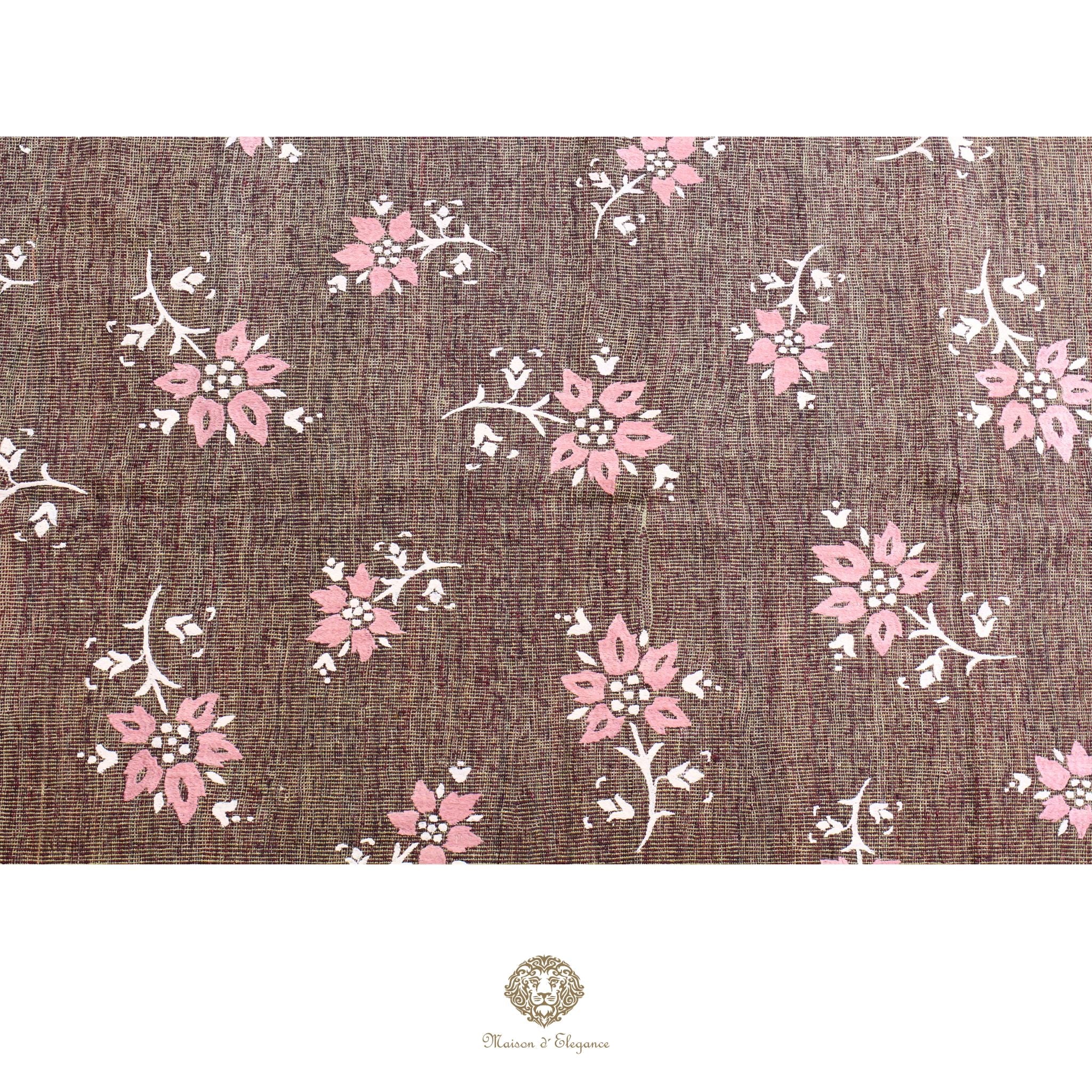 Floral pattern on a textured brown background with a brand logo at the bottom.