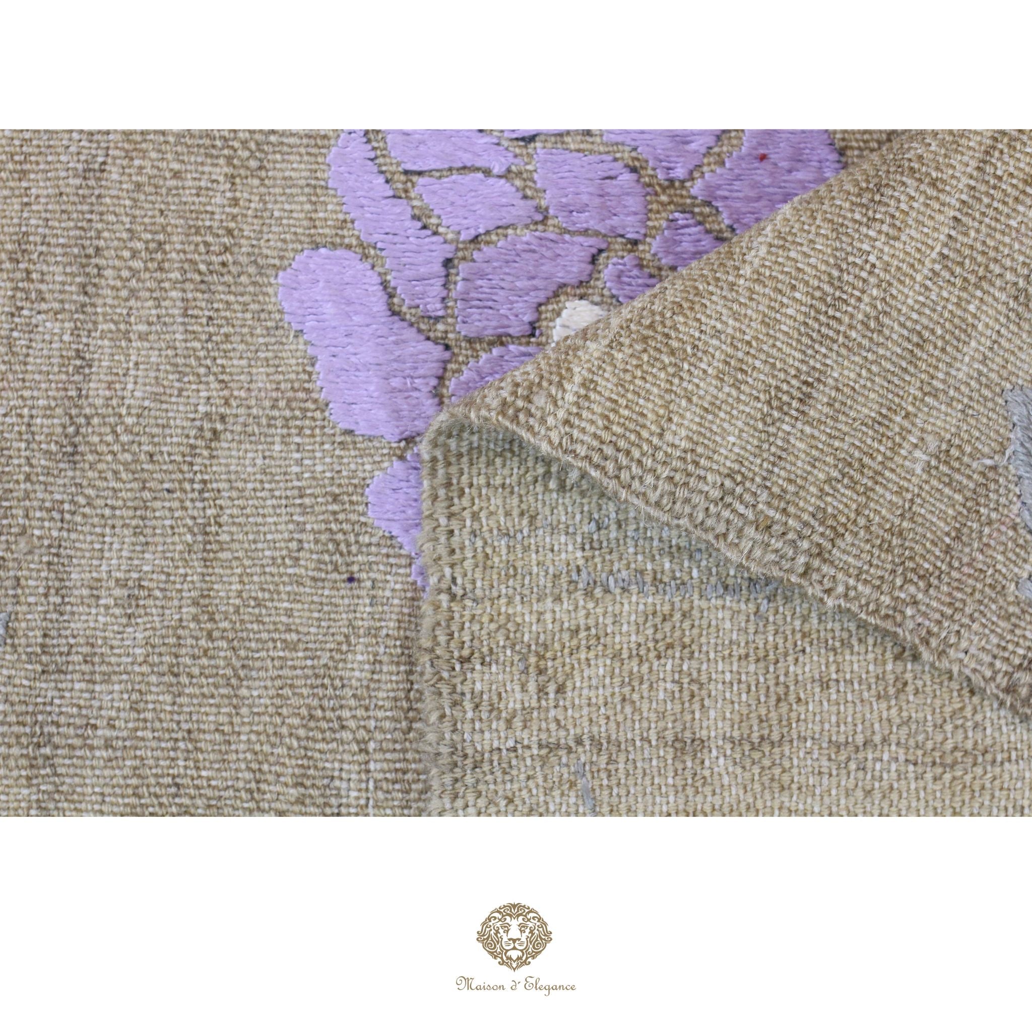 Close-up of a textured fabric with purple floral embroidery on a beige background