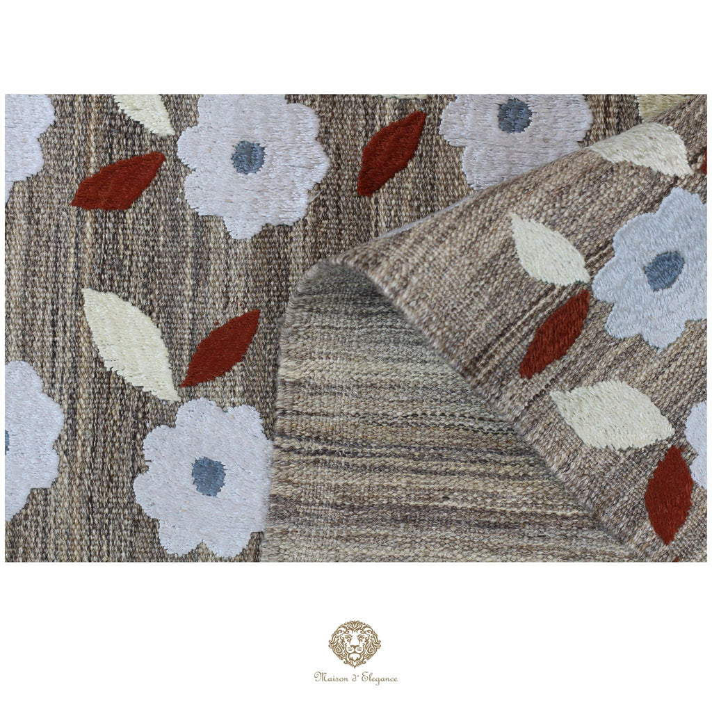 Textured rug with floral patterns and a brand logo at the bottom.