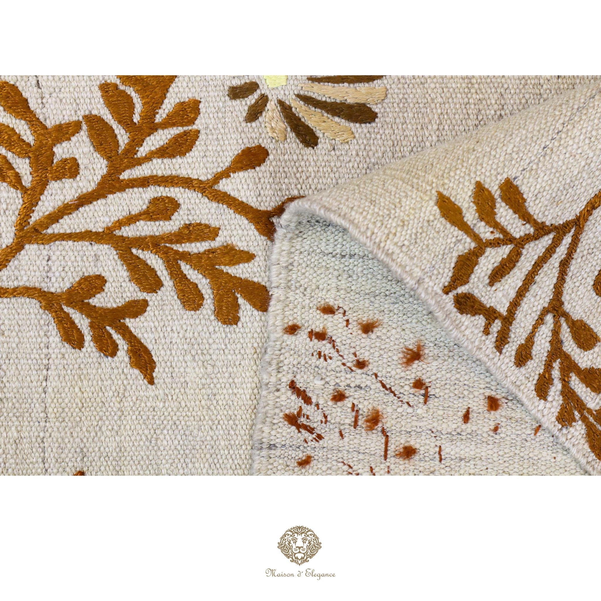 Close-up of a textured fabric with brown leaf patterns on a beige background, featuring the brand 'Chandra Rugs'.