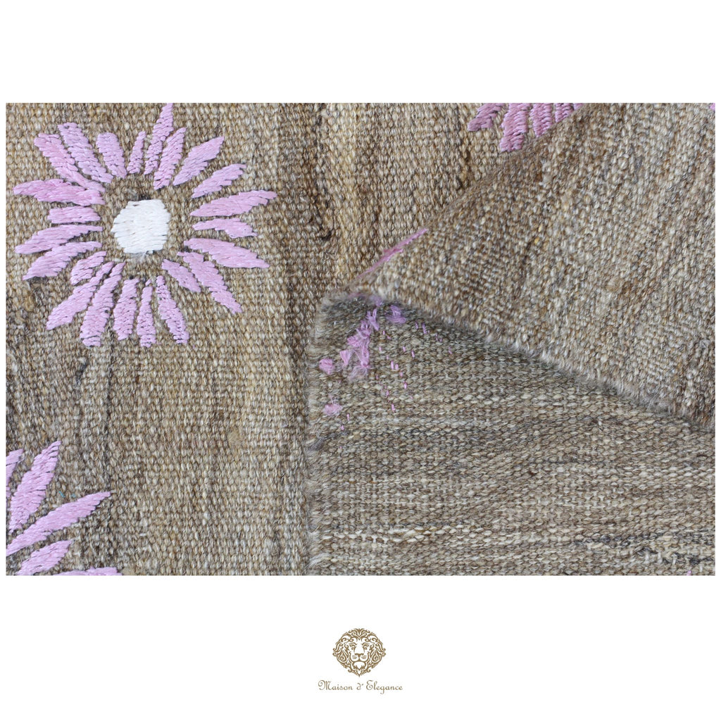 Textile with embroidered pink flowers on a beige background