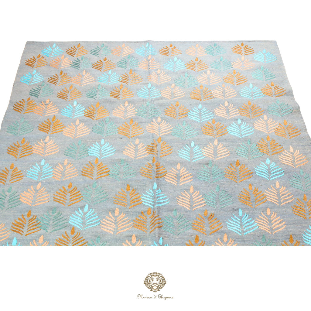 Patterned fabric with leaf design on a gray background, featuring gold and blue colors.