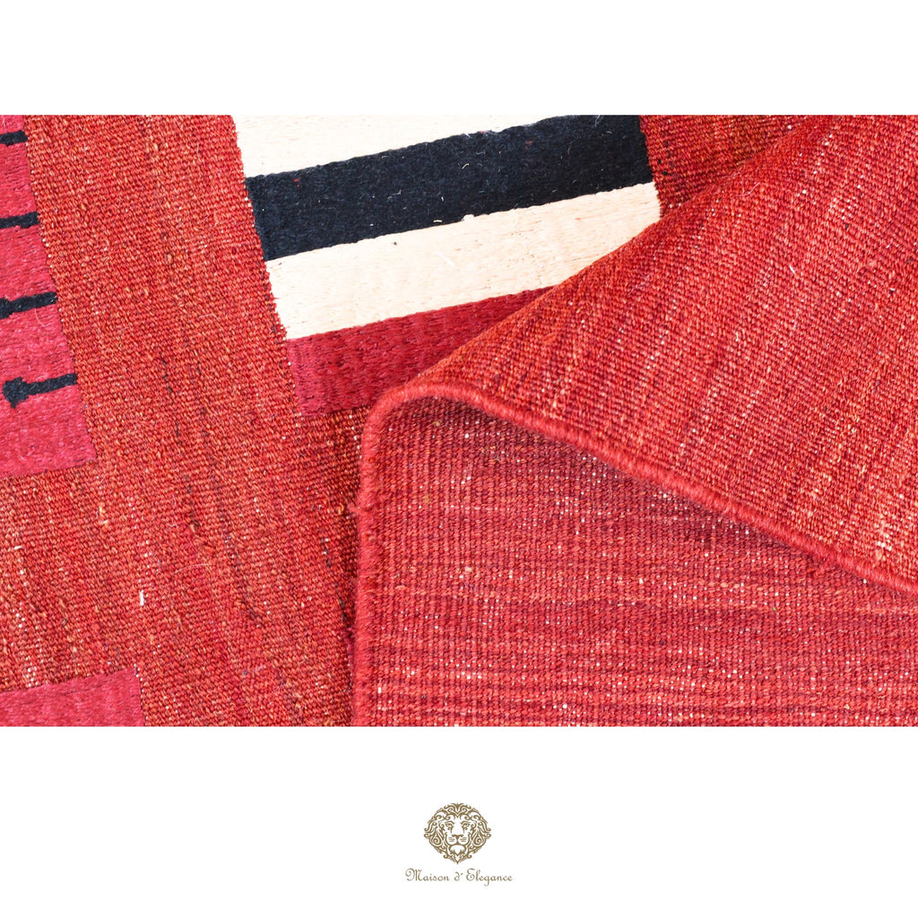 Close-up of a textured red fabric with a brand logo at the bottom.