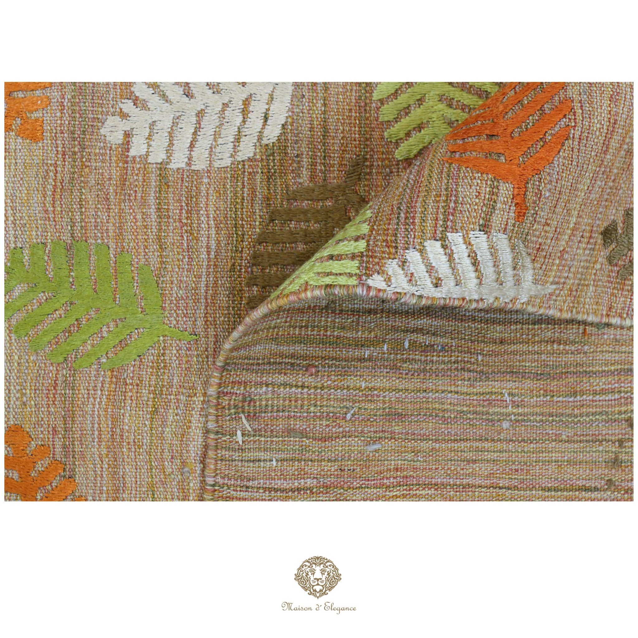 Textile with leaf pattern featuring orange, green, and brown colors on a white background.