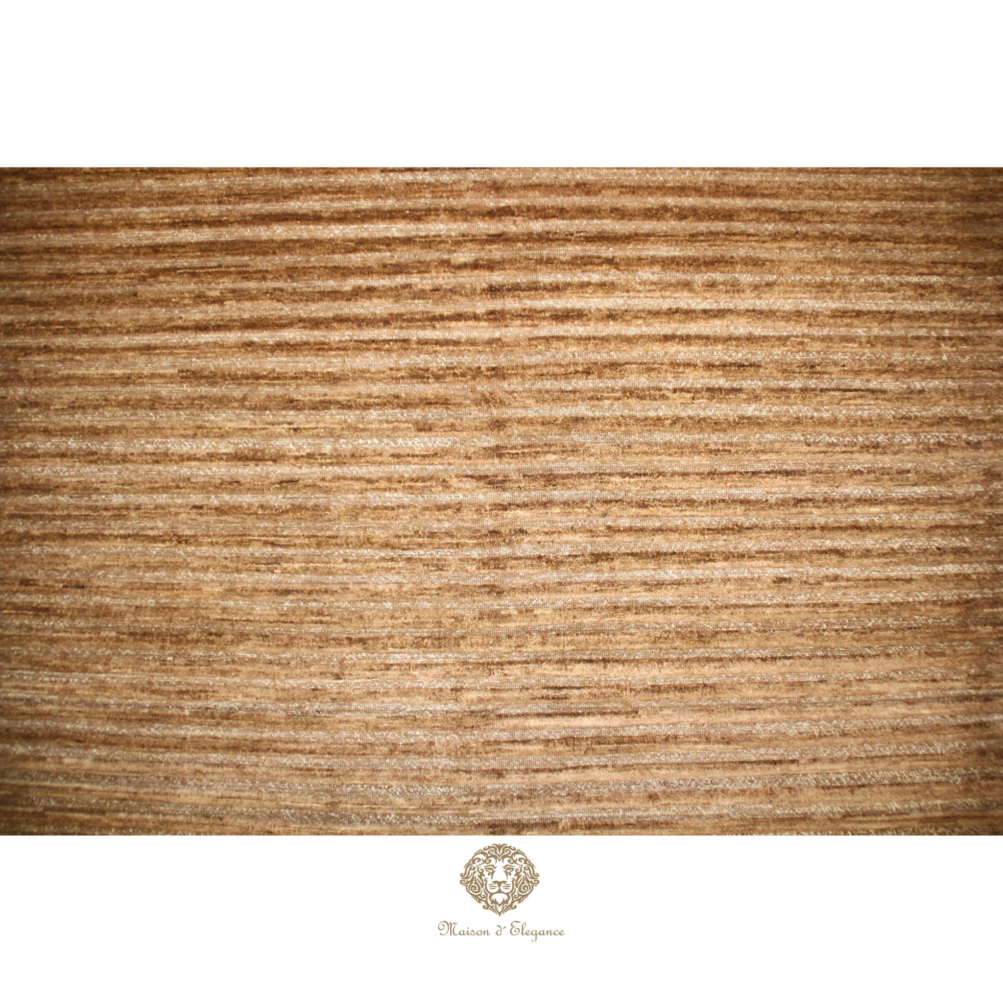 Textured brown rug with a brand logo at the bottom right corner