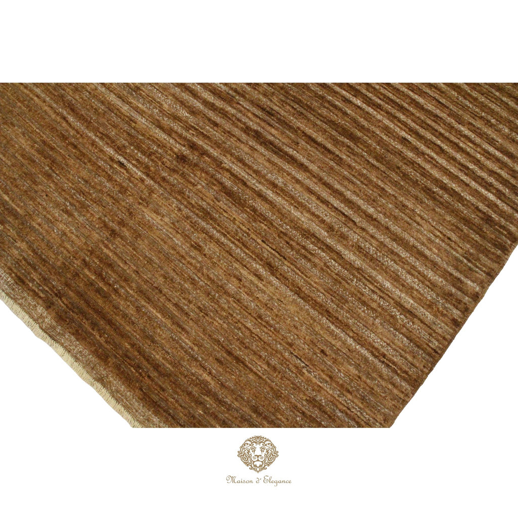 Close-up of a brown textured rug with a brand logo at the bottom.