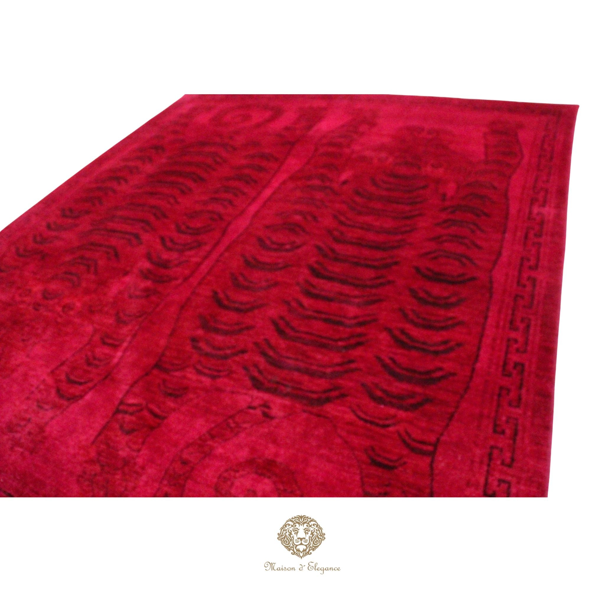 Red patterned rug with a brand logo at the bottom right corner on a red background