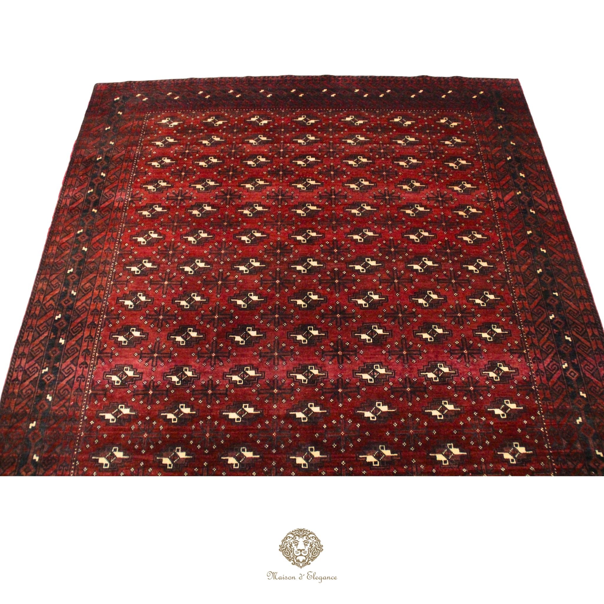 Red patterned rug with a brand logo at the bottom right corner on a red background