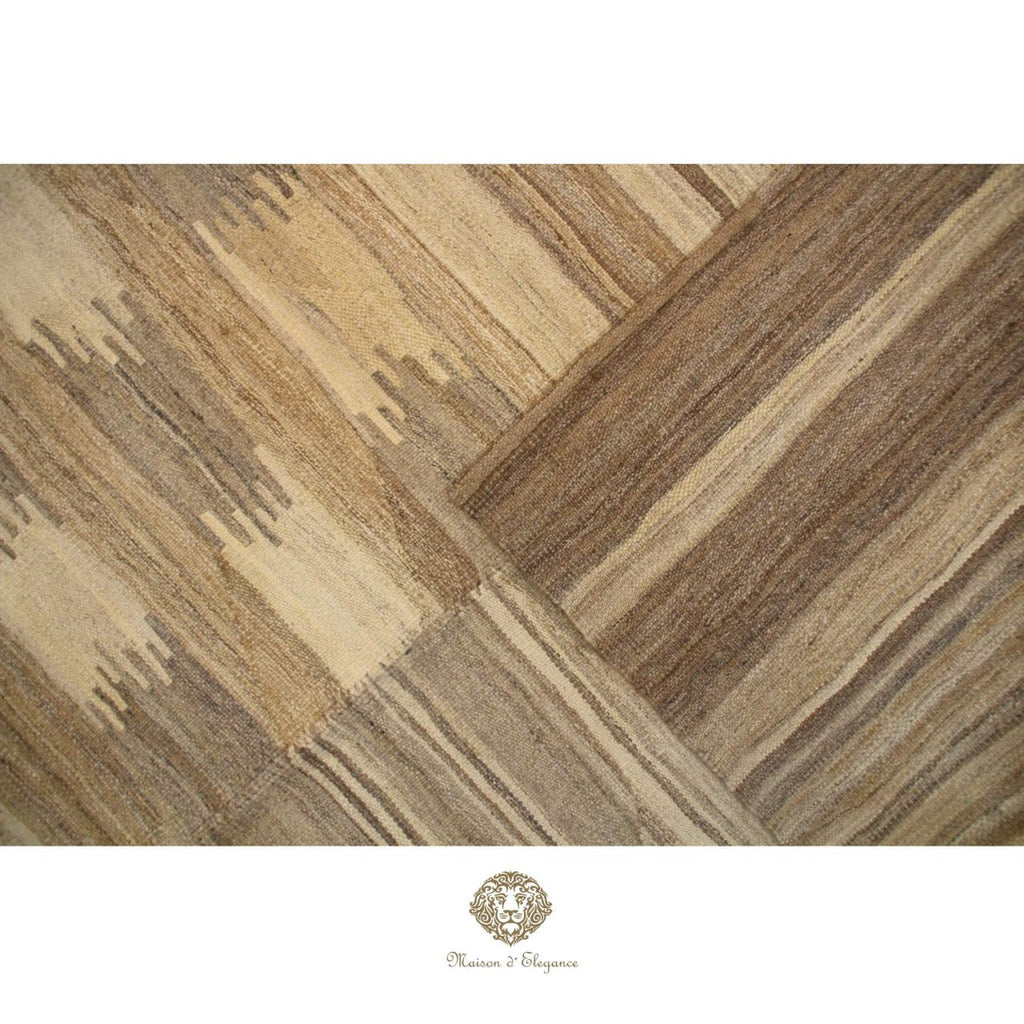 Wooden flooring with a herringbone pattern on a ivory  background, featuring a brand logo at the bottom.