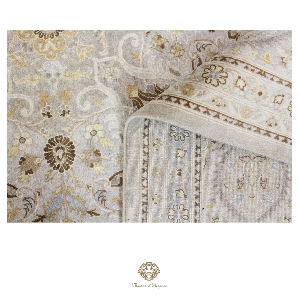 Close-up of an ornate rug with intricate patterns and a brand logo at the bottom.