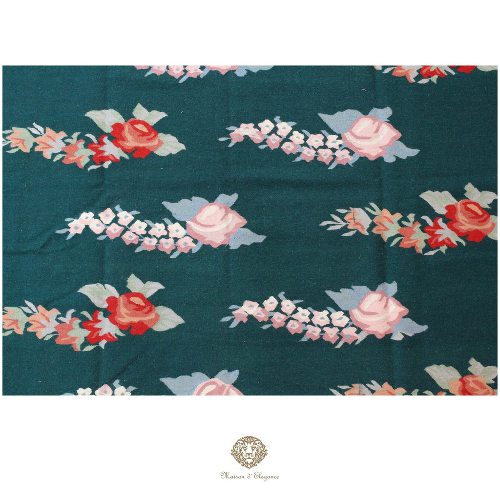 Floral patterned fabric with roses and leaves on a teal background