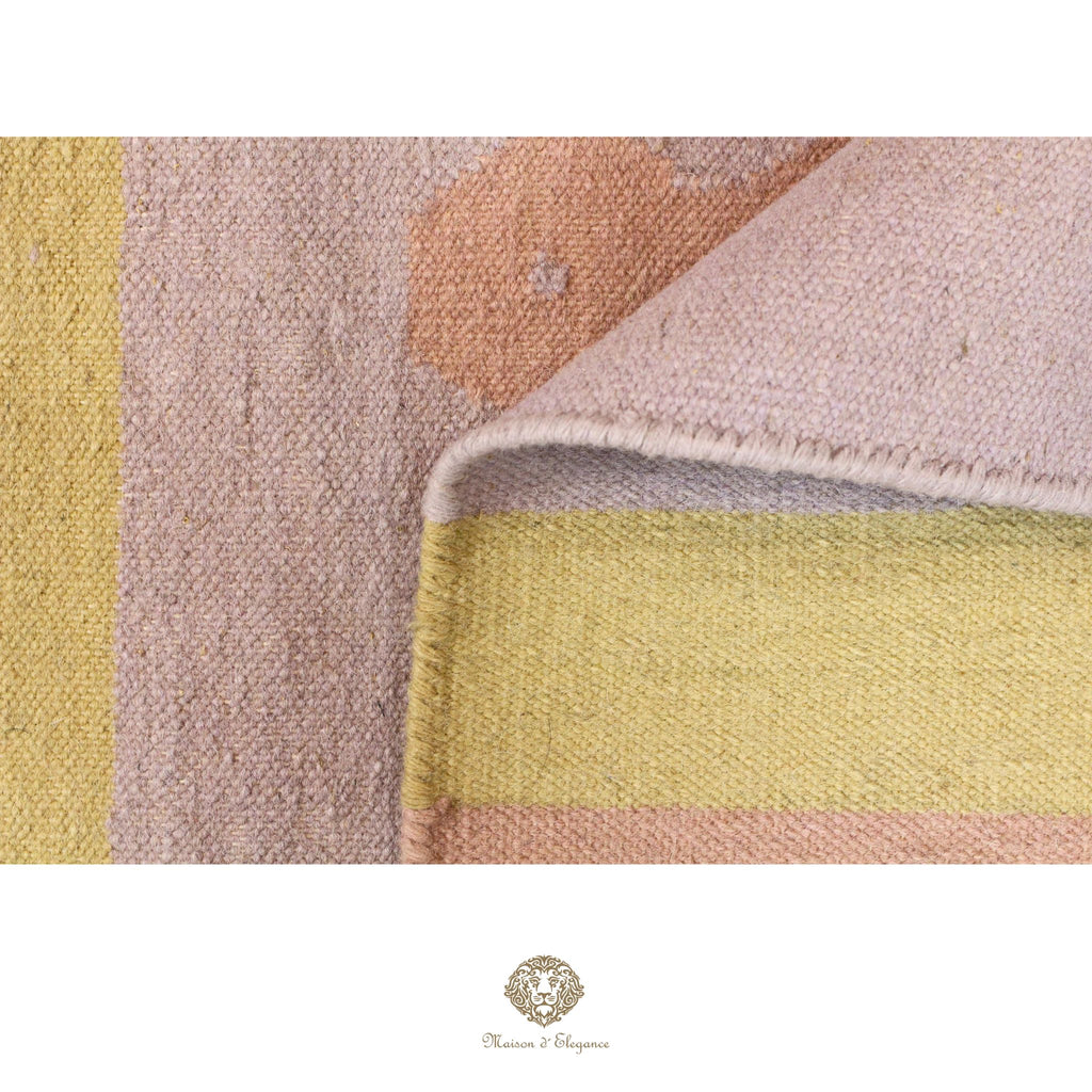Close-up of a textured fabric with geometric pattern in soft colors, featuring a brand logo at the bottom.
