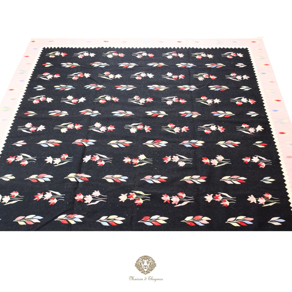 Floral patterned fabric on a black background with a visible brand logo.