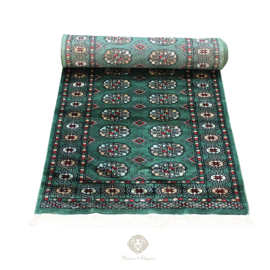 Roll of patterned teal rug on a white background