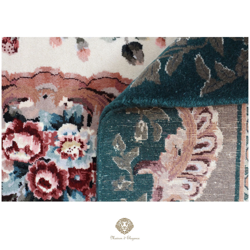 Close-up of a floral patterned rug with a brand logo at the bottom.