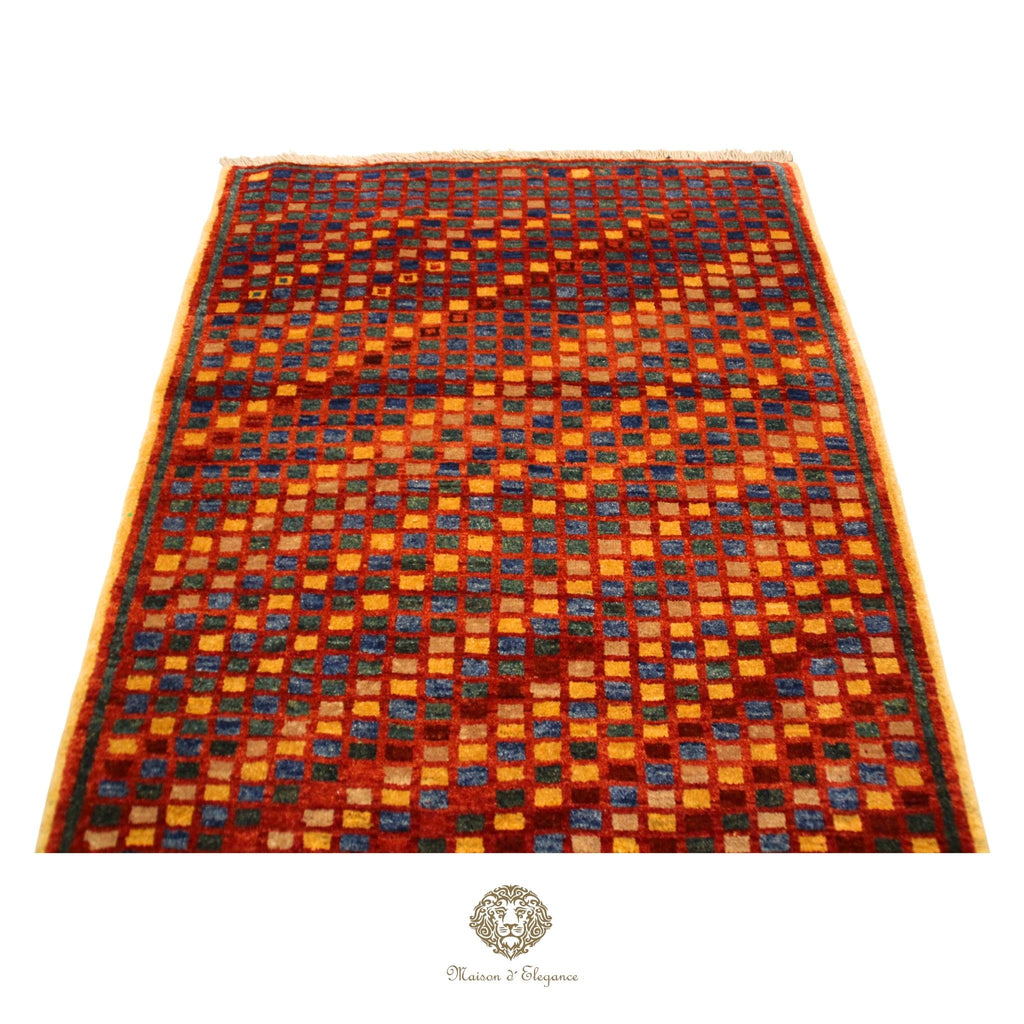 Checkered patterned rug with a brand logo at the bottom center on a red background