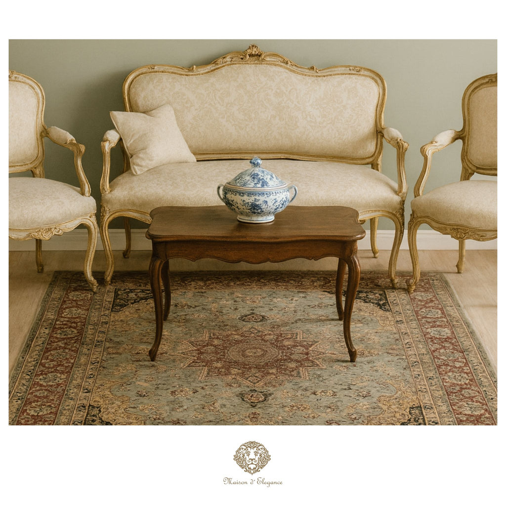 Vintage-style living room with beige sofa, armchairs, and a wooden coffee table with a decorative bowl.