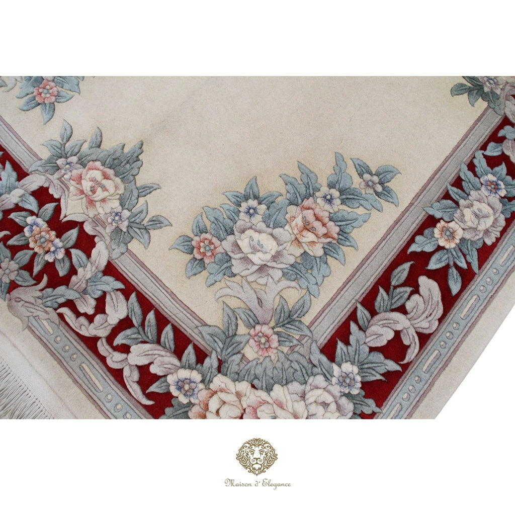 Decorative floral patterned rug with red border on a white background