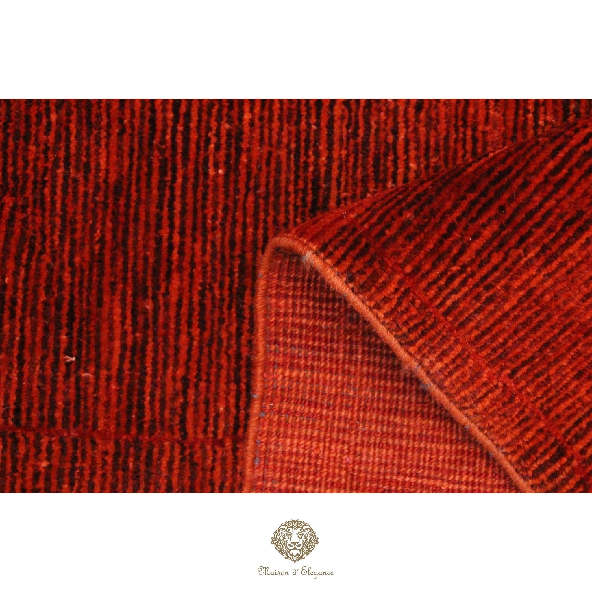 Close-up of a red textured fabric with a brand logo at the bottom.