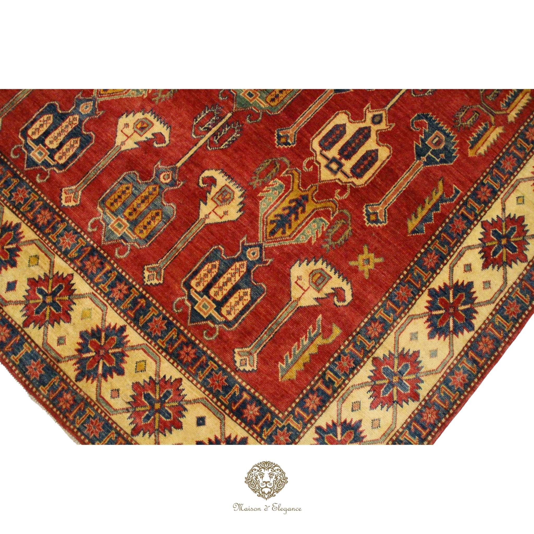 Close-up of a red patterned rug with intricate designs on a Burgundy background.