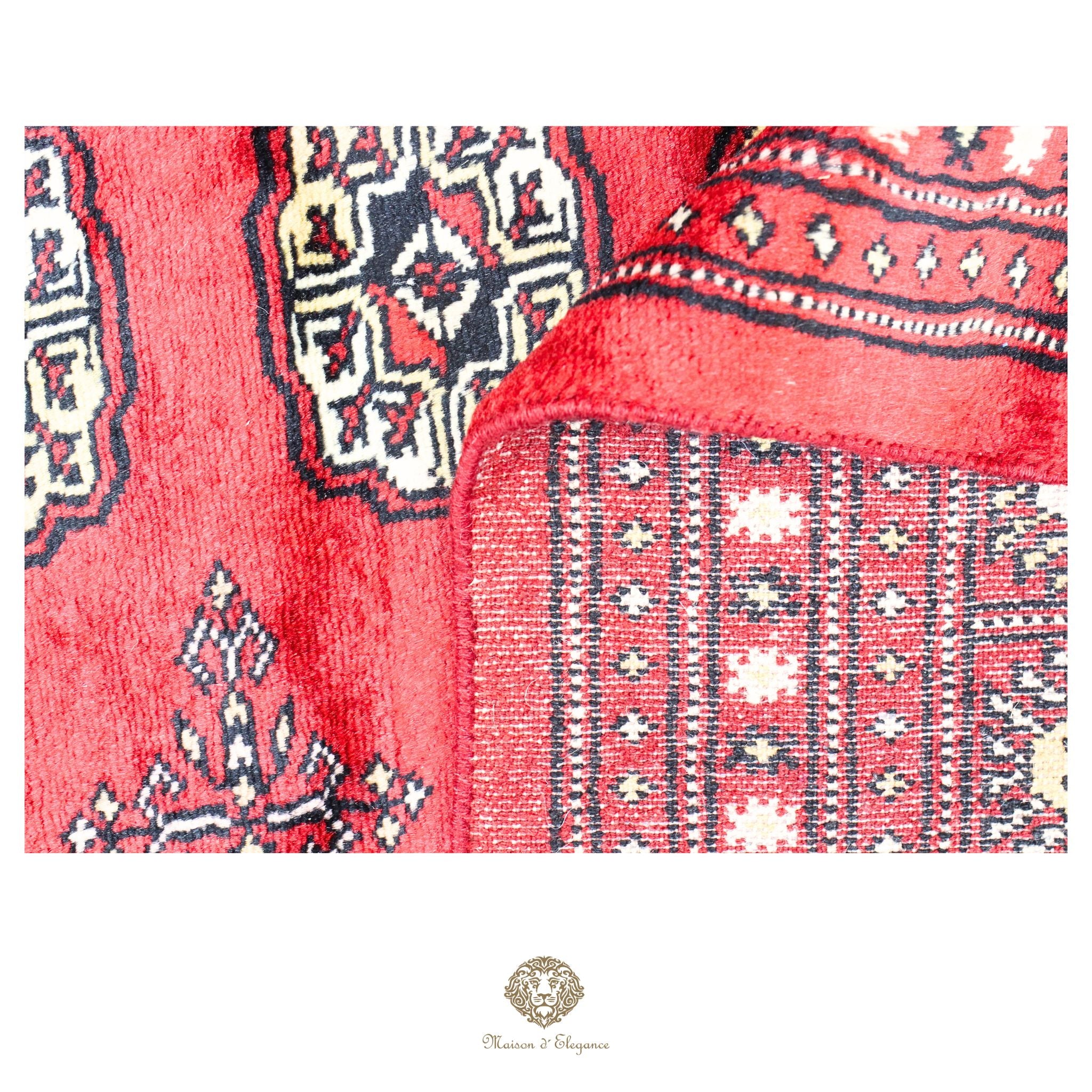Close-up of a red fabric with intricate patterns and a brand logo at the bottom.