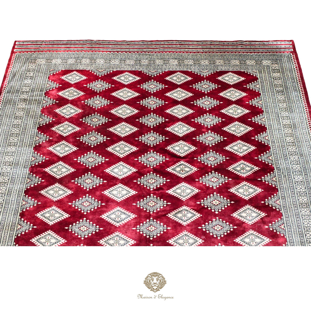 Decorative rug with red and gray geometric pattern on a red background