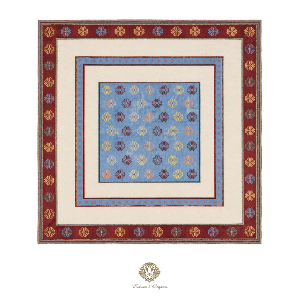 Decorative quilt with floral pattern and intricate border on a white background