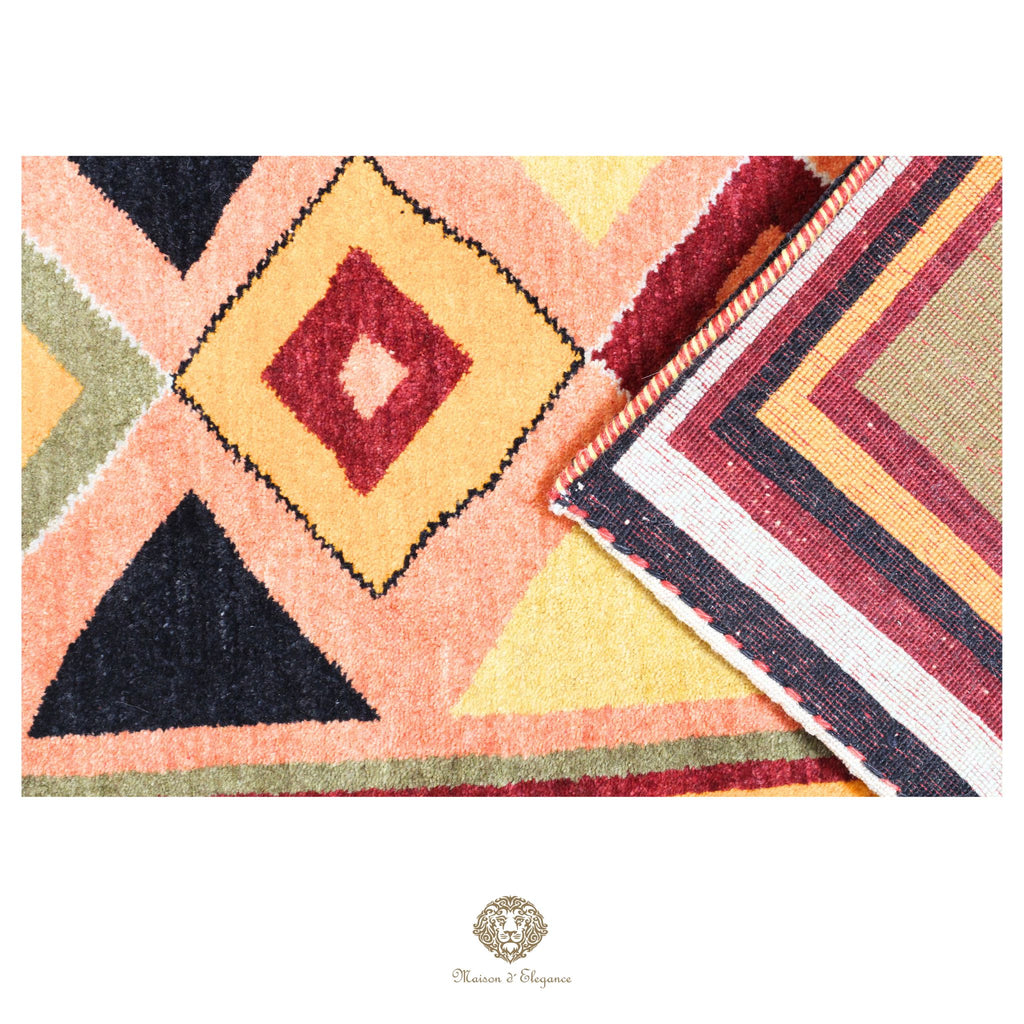 Colorful geometric patterned rug with a brand logo in the corner.