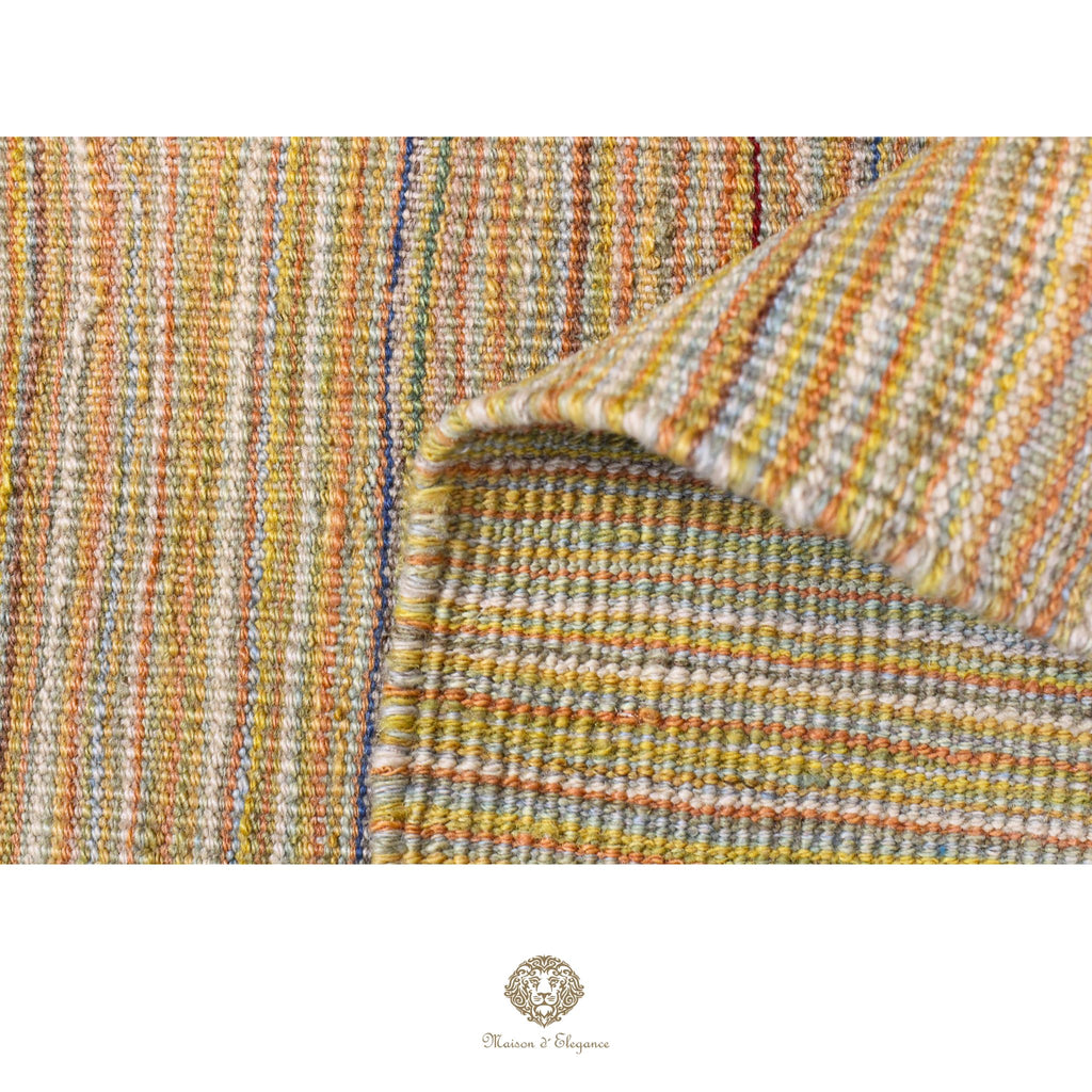 Close-up of a textured fabric with multicolor stripes on a white background, featuring the Charmin & Company logo.