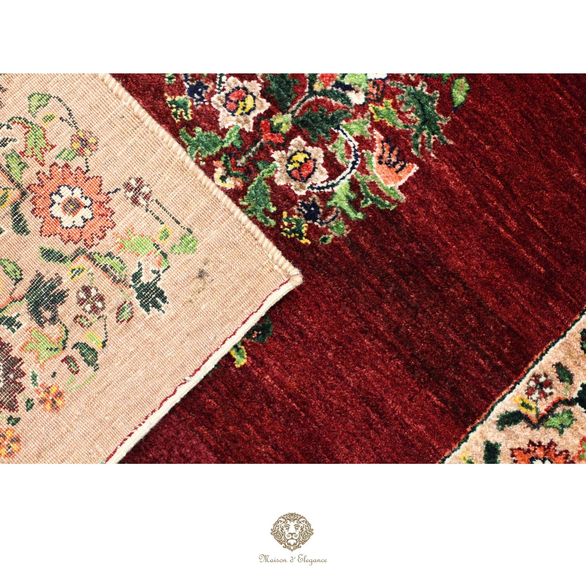 Close-up of a red floral patterned rug with a beige corner showing more intricate designs.
