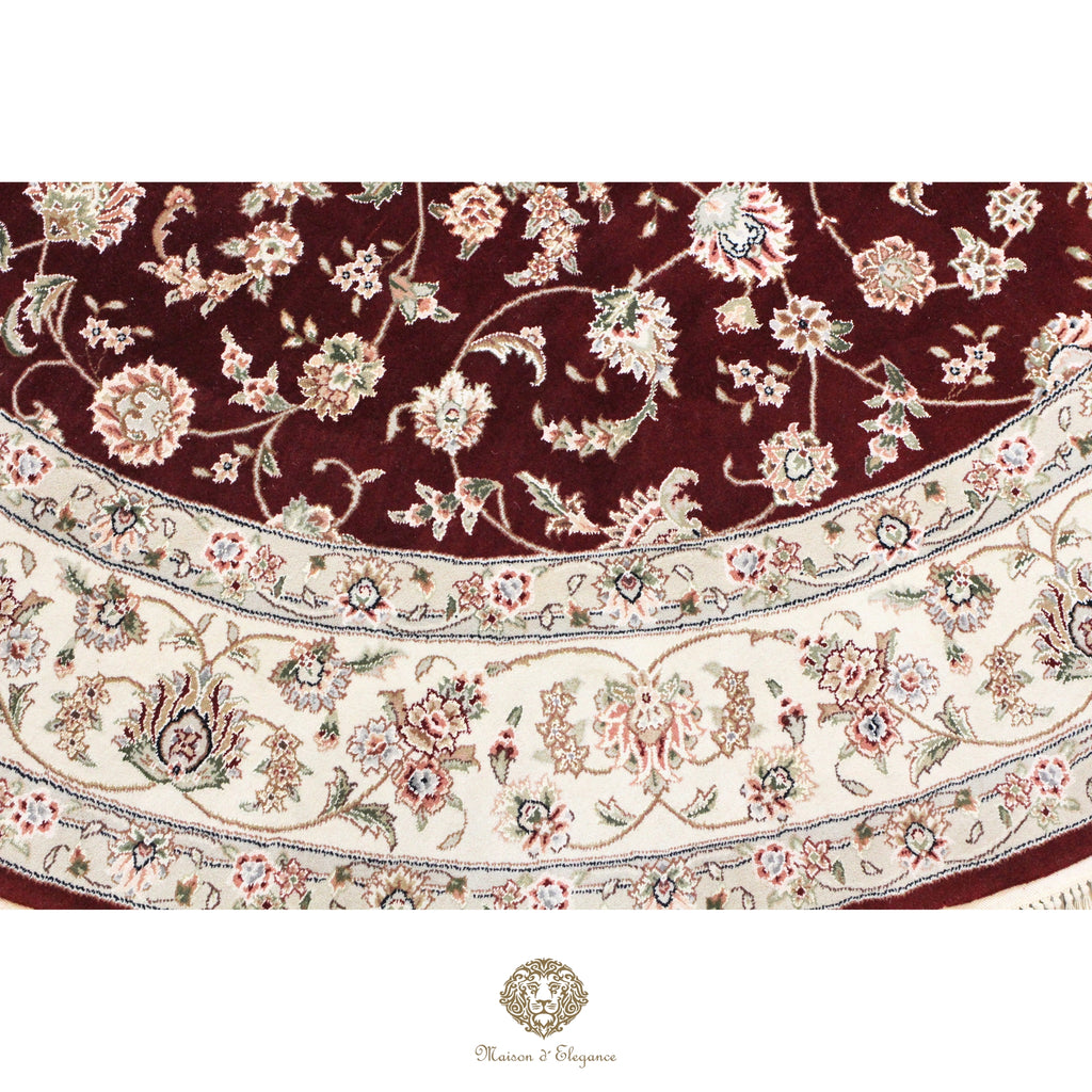 Close-up of a floral-patterned rug with intricate designs on a red background.