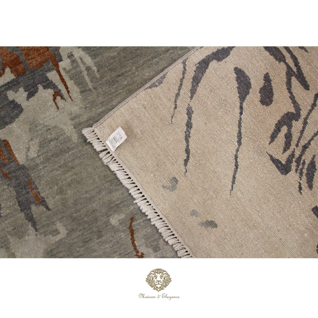 Close-up of a patterned rug with a brand logo at the bottom.