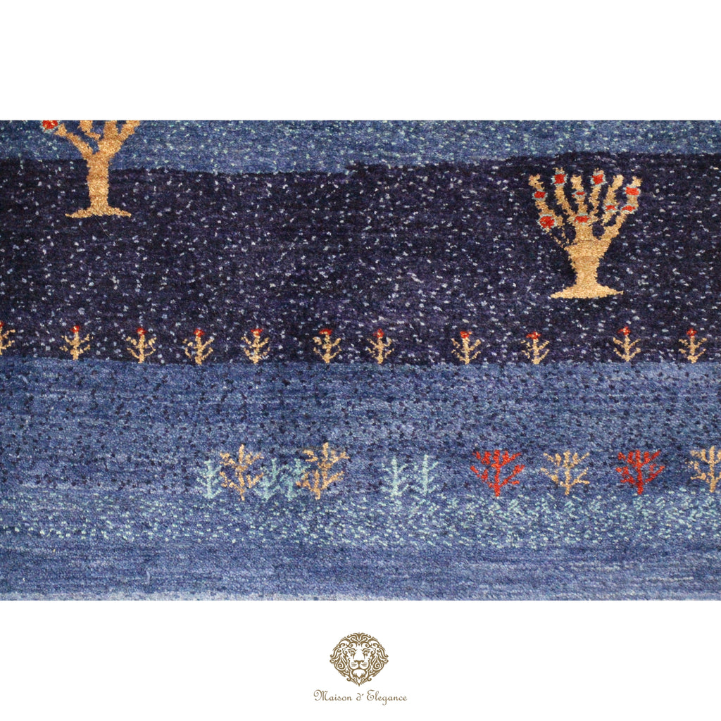 Textile with tree patterns on a blue background, featuring a brand logo at the bottom.