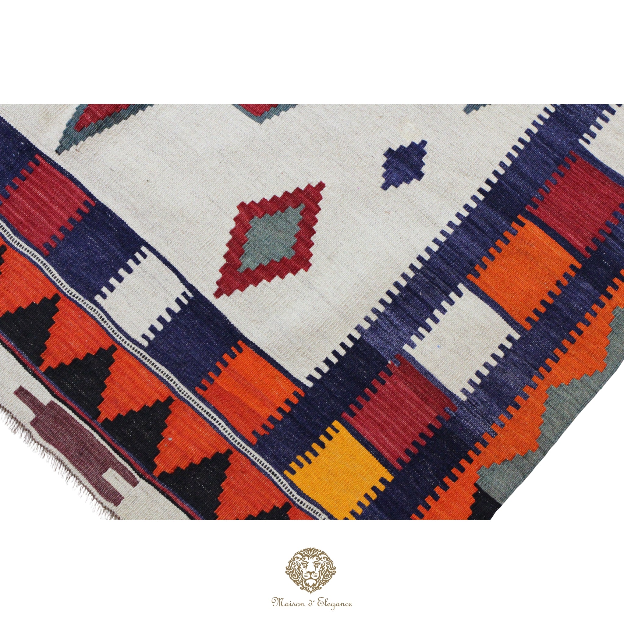 Colorful geometric patterned rug with a brand logo at the bottom right corner.