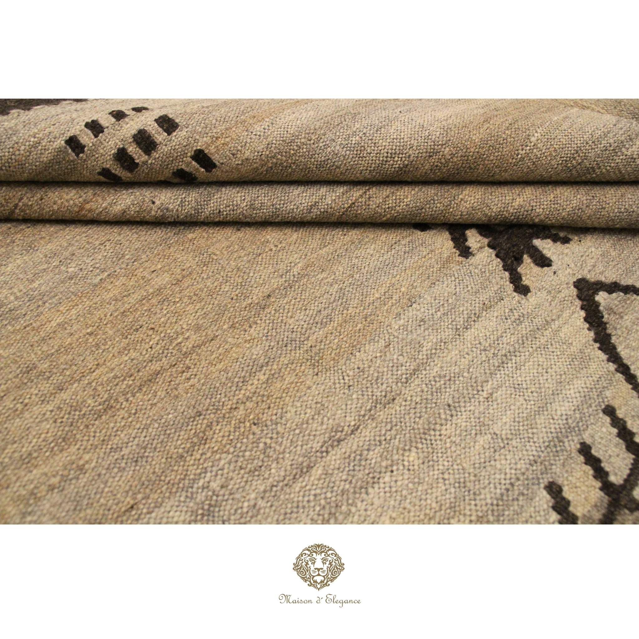 Textured fabric with black pattern, possibly a rug or textile sample, on a ivory background.