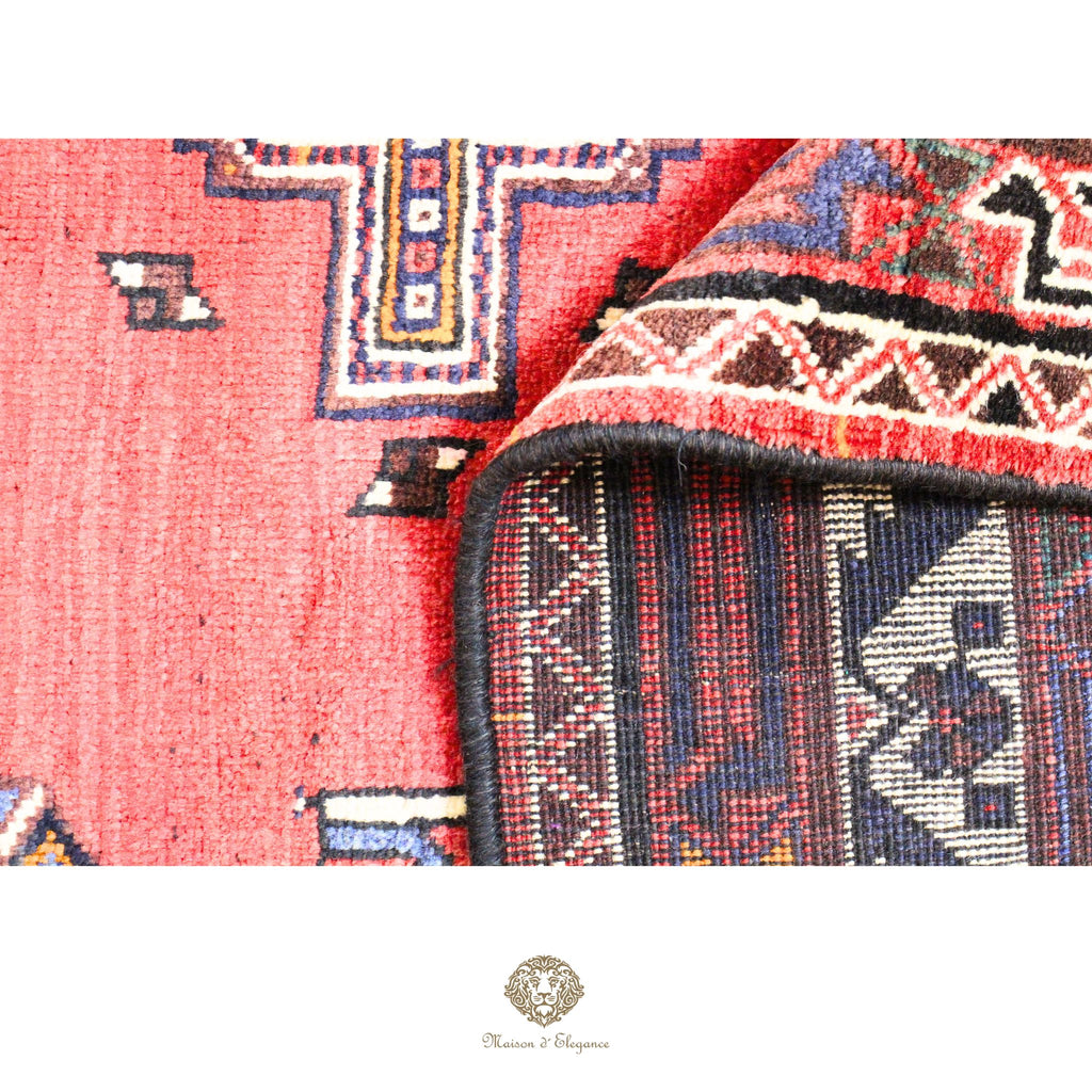 Close-up of a patterned rug with visible brand logo in the corner.