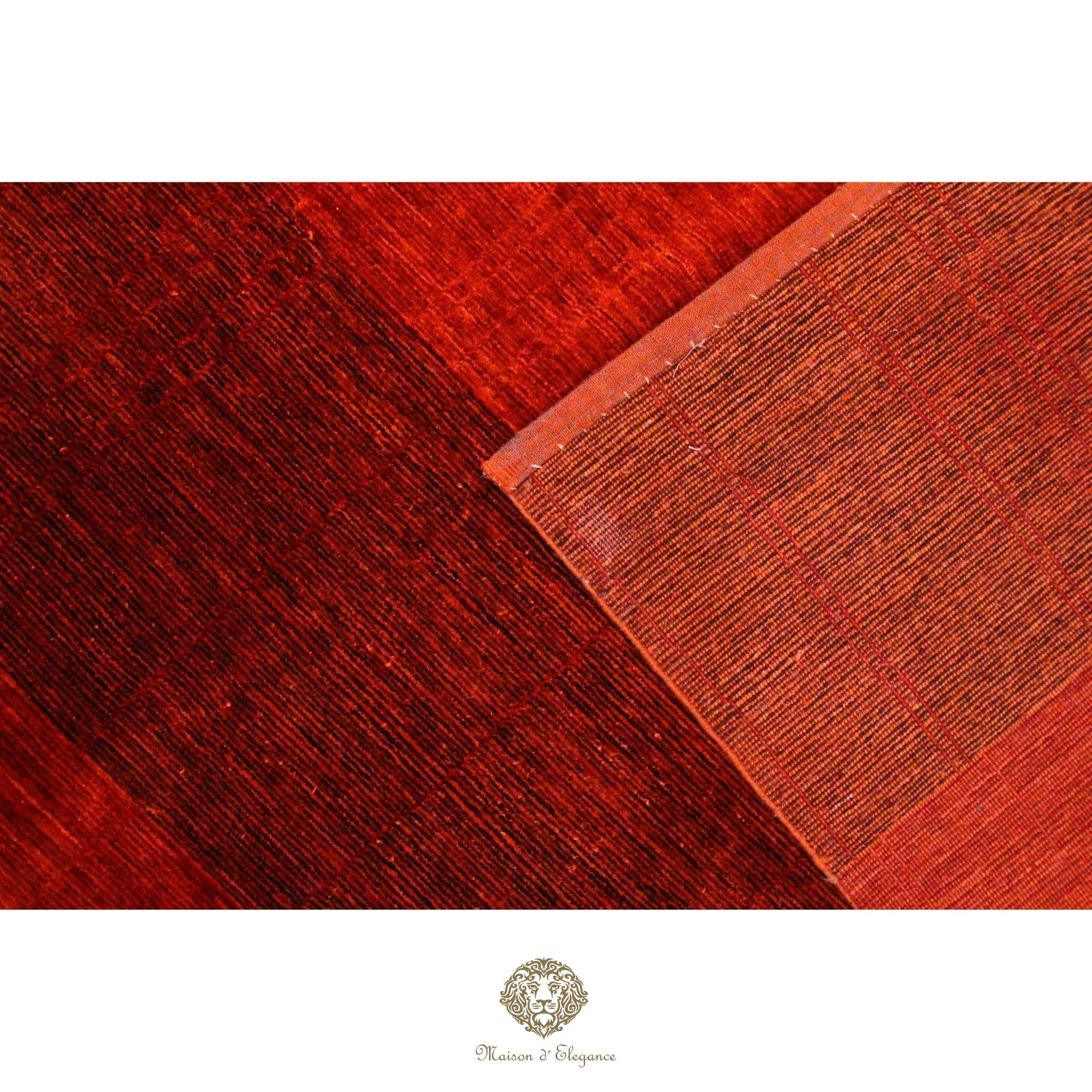 Close-up of red and brown leather texture with a brand logo at the bottom.