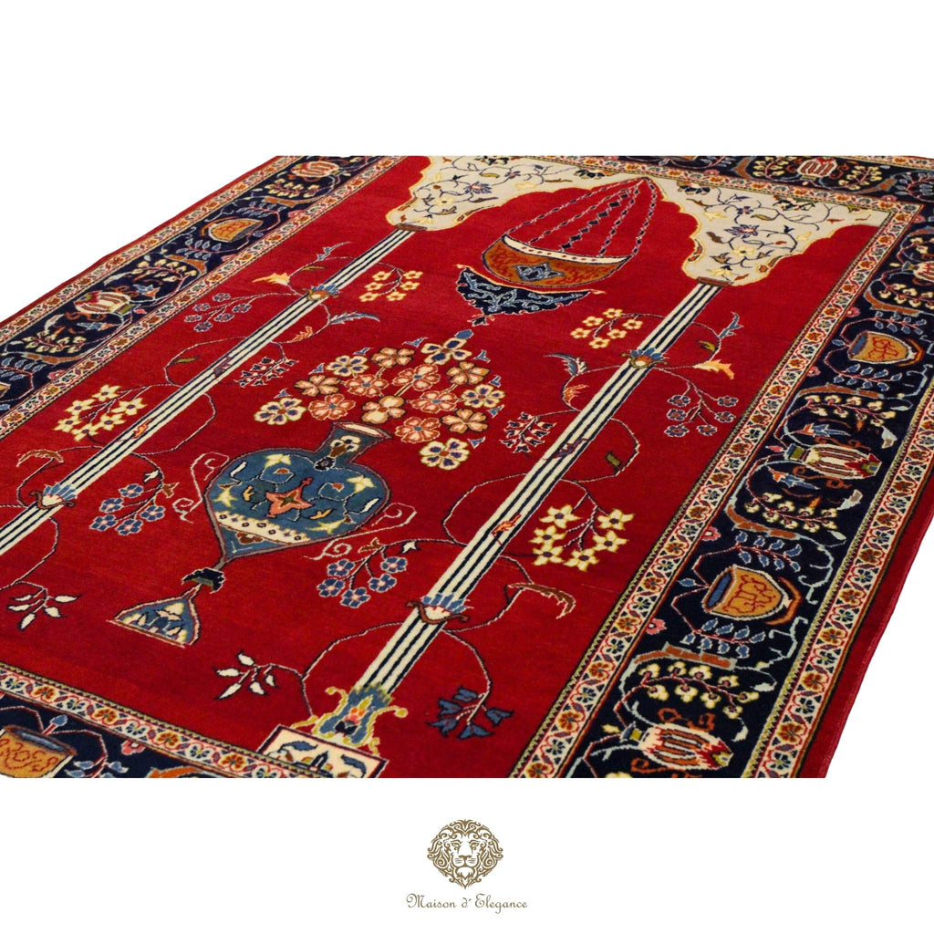 Decorative red rug with intricate patterns and a brand logo at the bottom.