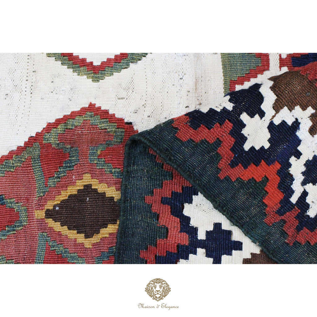 Close-up of a traditional patterned fabric with geometric designs on a white background.